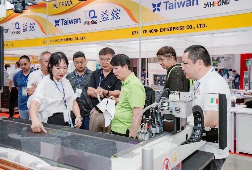 Buyers selecting cutting machine at Shoes and Leather Vietnam by Top Repute Co. Ltd.